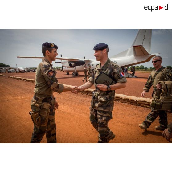 Le général de brigade Pierre Gillet, commandant la force Sangaris, est reçu par un officier des troupes de marine sur l'aérodrome de la POD (plateforme opérationnelle défense) de Bambari, dans le cadre de sa visite aux soldats du GTIA (groupement tactique interarmes) Turco.