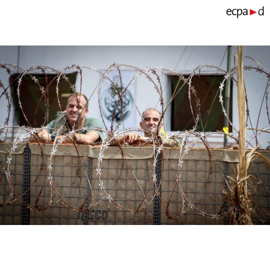 Deux officiers du GTIA (groupement tactique interarmes) Turco posent pour une photographie, accoudés à un Hesco bastion fortifiant les locaux du poste de commandement de la POD (plateforme opérationnelle défense) de Bambari.