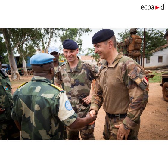 Le colonel Marc Espitalier, chef de corps du 1er RT et commandant le GTIA (groupement tactique interarmes) Turco, salue un lieutenant-colonel de l'armée démocratique congolaise composante des casques bleus, sur la place du siège régional de la MINUSCA (mission multidimensionnelle intégrée des Nations Unies pour la stabilisation en Centrafrique), lors de la visite du général de brigade Pierre Gillet, commandant la force Sangaris, aux soldats de la POD (plateforme opérationnelle défense) de Bambari.