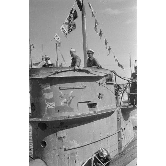 Le sous-marin U-69 dans le port de Saint-Nazaire, des fanions de victoires sont visibles, l'insigne du sous-marin également (une vache qui rit).