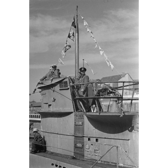 Le sous-marin U-69 dans le port de Saint-Nazaire, des fanions de victoires sont visibles, l'insigne du sous-marin également (une vache qui rit).