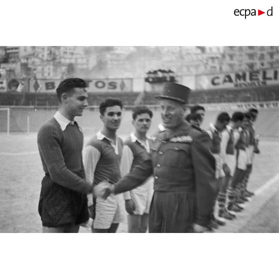 Poignée de main entre un général de division et une équipe de football militaire lors de la finale d'un championnat à Alger.