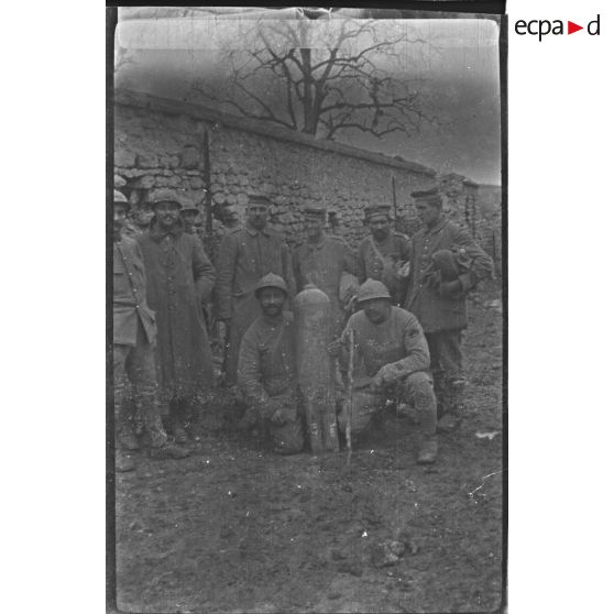 [Portrait de groupe de militaires français et de prisonniers allemands devant un obus, 1914-1918.]