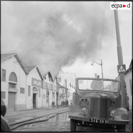 Intervention de sapeurs-pompiers durant un incendie dans un village.