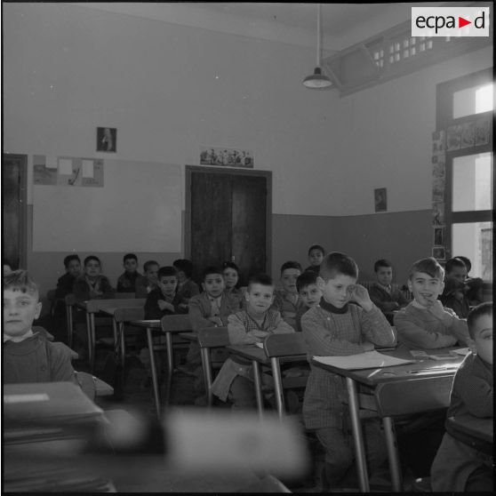 Vue d'une salle de classe où des élèves assistent à une leçon.