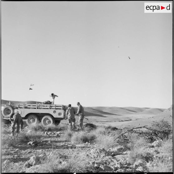 Trois militaires s'affairent autour d'un véhicule Dodge T223 (WC62 ou WC63) sur lequel est monté un canon sans recul M20 de 75 mm.