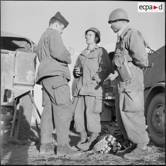 Photographie en pied de trois militaires.