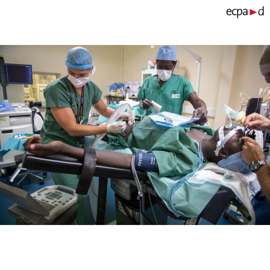 Le médecin principal Jean-Vivien, médecin réanimateur, et l'infimier anesthésiste Fabrice préparent un patient pour une opération chirurgicale au pôle de santé unique (PSU) de N'Djamena, au Tchad.