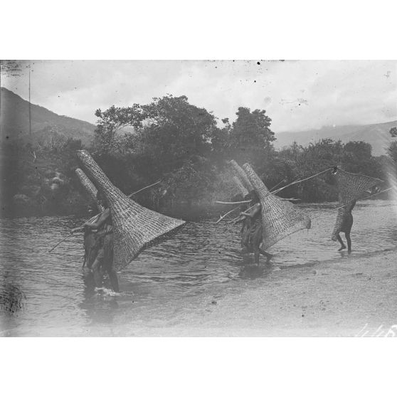 [Pêcheurs transportant leurs nasses au bord de la rivière.]