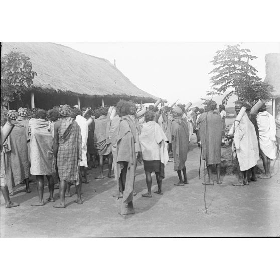 [Des Malgaches chargés de nattes sont rassemblés devant une habitation du village de Betroka.]