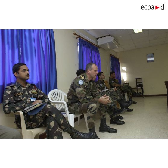 Militaires assistant en retrait au point de situation.