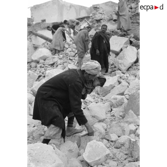 La population civile récupère des objets dans les ruines de la ville de Gafsa.