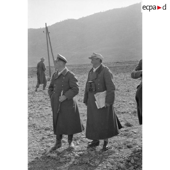 Le maréchal (Generalfeldmarschall) Rommel et le colonel (Oberst) Bayerlein discutent, entourés d'officiers.