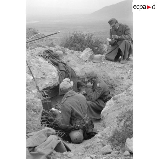 Des opérateurs radio travaillent à l'abri d'un creux dans les rochers, au sommet d'une colline.