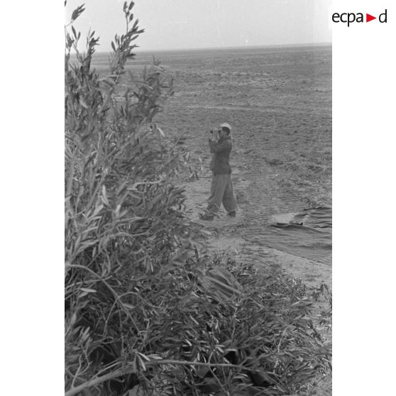 Un membre de l'équipage du char Panzer III observe le terrain à la jumelle.