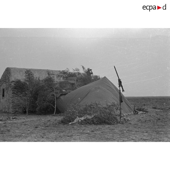 Tente de l'équipage d'un char Panzer III (Pz-III Ausf-L) appuyé contre le mur d'une habitation.