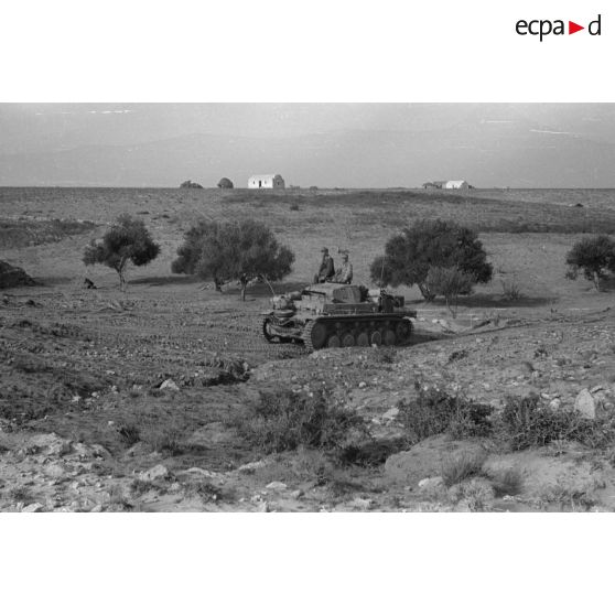 Un char Panzer II (Pz-II Ausf-C) de l'état-major d'un deuxième bataillon roule près d'un groupe d'habitation.