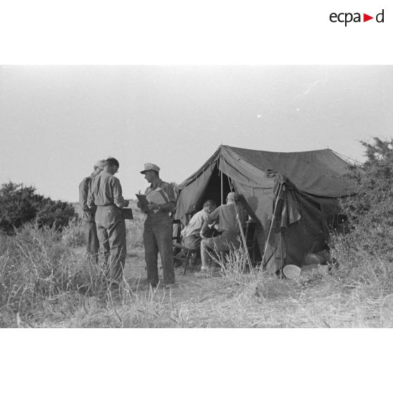 Un groupe de soldats et d'officiers allemands discutent près d'une tente.