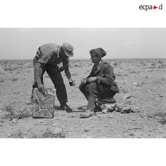 Un soldat allemand verse de l'eau dans un gobelet pour un bersaglier.