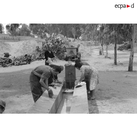 Des mécaniciens du Nachschubkolonne Abteilung 909 au lavoir en compagnie de civils.