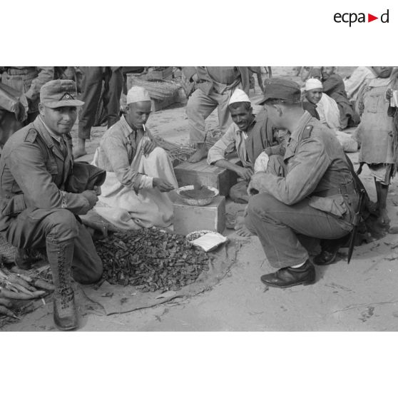 Deux soldats allemands dans un marché, on remarque la bande de bras Afrikakorps sur le bras droit du soldat de gauche.