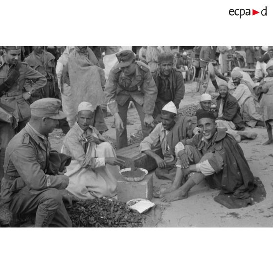 Deux soldats allemands dans un marché, on remarque la bande de bras Afrikakorps sur le bras droit du soldat de gauche.