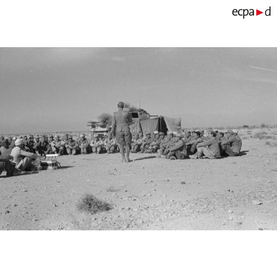 Des soldats de la 6e compagnie du Panzer Regiment 5 (Pz.Rgt-5) sont réunis en demi-cercle devant une tente et un char Panzer III (Pz-III Ausf H).