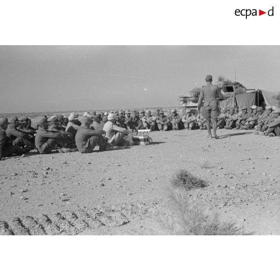 Des soldats de la 6e compagnie du Panzer Regiment 5 (Pz.Rgt-5) sont réunis en demi-cercle devant une tente et un char Panzer III (Pz-III Ausf H).