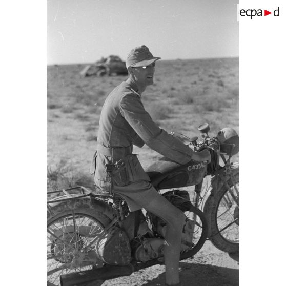 Portrait d'un officier allemand installé aux commandes d'une moto d'origine britannique.