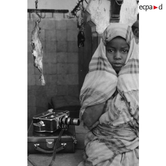 Dans un marché de Tripoli, le reporter photographie un enfant et la caméra 16 mm d'un caporal allemand.