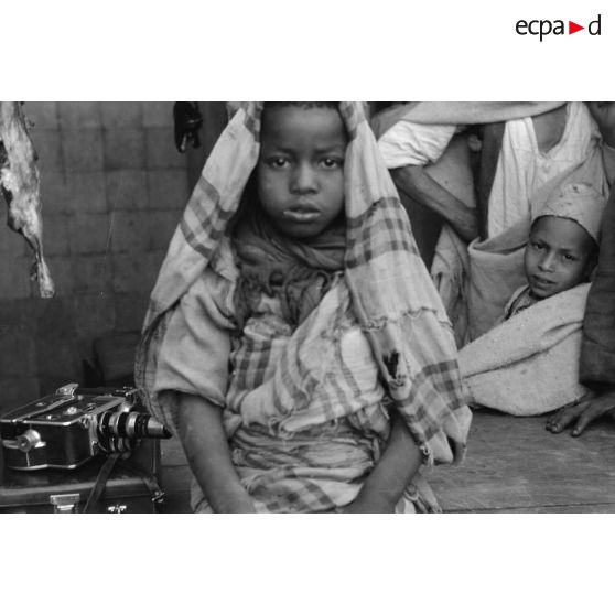 Dans un marché de Tripoli, le reporter photographie un enfant et la caméra 16 mm d'un caporal allemand.