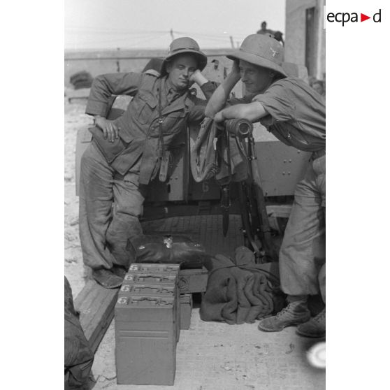 Deux artilleurs allemands devant un canon de DCA de 2 cm FlaK 30 qui vient d'être déchargé sur le quai du port de Tripoli.