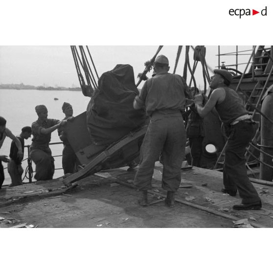 Déchargement d'un canon de DCA allemand qui vient de traverser la Méditerranée à bord d'un navire italien.