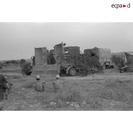 La scène est installée sur la plate-forme d'un camion Opel Blitz, des soldats jouent de la musique et chantent.