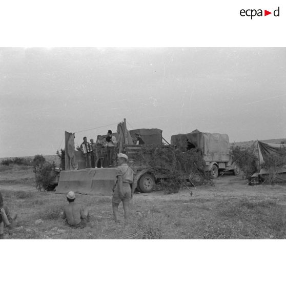 La scène est installée sur la plate-forme d'un camion Opel Blitz, des soldats jouent de la musique et chantent.