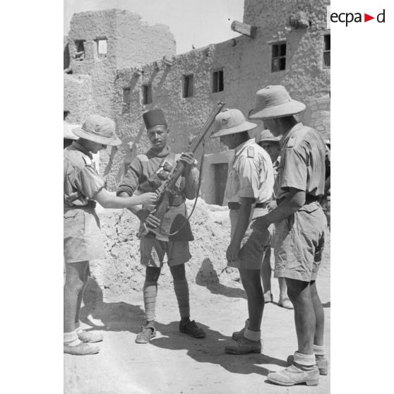 Trois soldats allemands de la Luftwaffe examinent le fusil Lee-Enfield Mark III d'un policier égyptien.