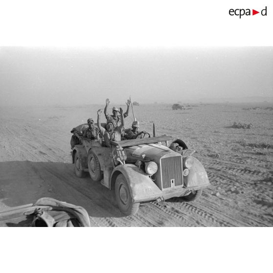 Une Horch Kfz.15 progresse à proximité du véhicule des reporters dont un aperçoit la capote du véhicule cabriolet.