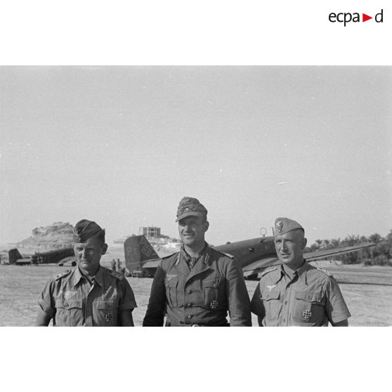 Deux capitaines de la Luftwaffe posent en compagnie d'un Leutnant de l'armée de terre, derrière les Junkers Ju-52 posés sur le terrain de Siwa.