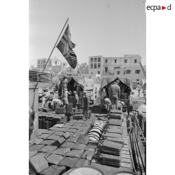 Activités dans le port de Tobrouk, déchargement d'essence (jerrycans et futs) par des prisonniers alliés.