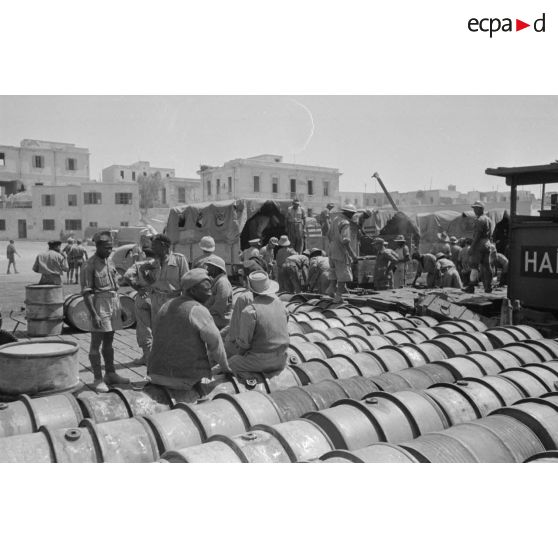 Activités dans le port de Tobrouk, déchargement d'essence (jerrycans et futs) par des prisonniers alliés.