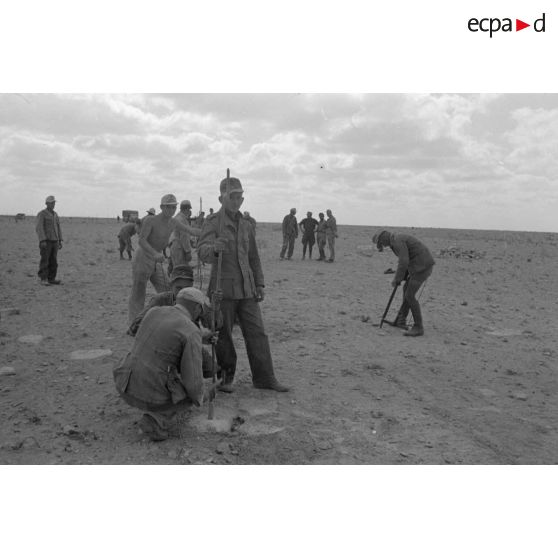 Des soldats allemands et italiens posent un réseau de barbelés.