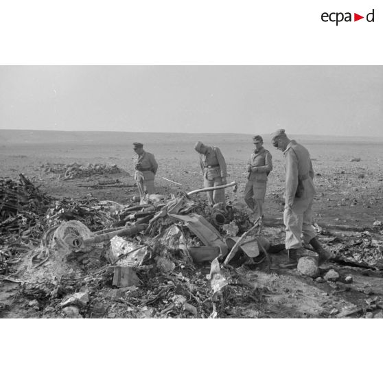 Des soldats de la Luftwaffe fouillent une épave calcinée d'avion bimoteur potentiellement d'origine britannique.