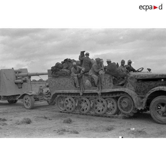 Progression d'un semi-chenillé Sd.kfz.7 tractant une pièce de 8,8 cm FlaK.