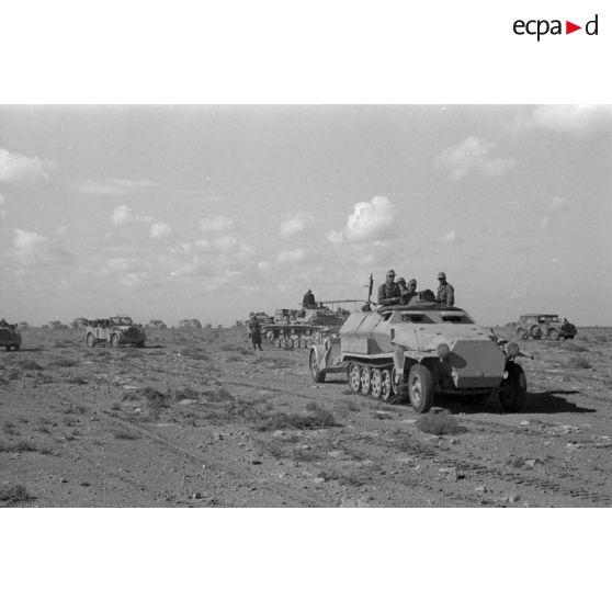 Un semi-chenillé Sd.kfz.251 dépasse un char de commandement Panzer III (Befehlpanzer III) et un Sd.kfz.251/3.