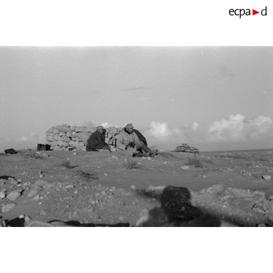 Le capitaine Walter Fromm, commandant du I./FlaK-Regiment 33 se protège durant un tir d'artillerie.