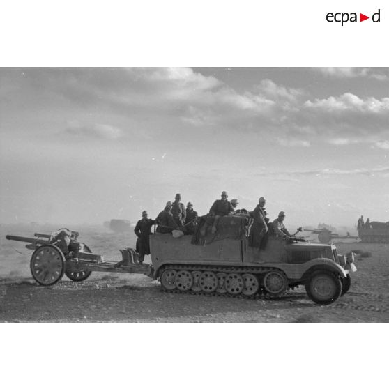 Des semi-chenillés Sd.kfz.11 progressent avec des pièces d'artillerie de 10,5 cm FH 18.