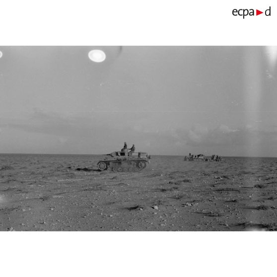 Un Panzer III (Befehlpanzer III) et un semi-chenillé Sd.kfz.7 tractant un canon de 8,8 cm FlaK.