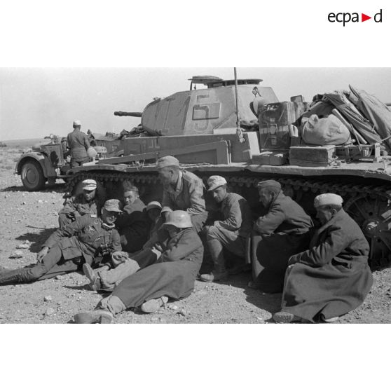 Des artilleurs du I./Flak-Regiment 33 se reposent à l'abri d'un Panzer II du Panzer-Regiment 8.