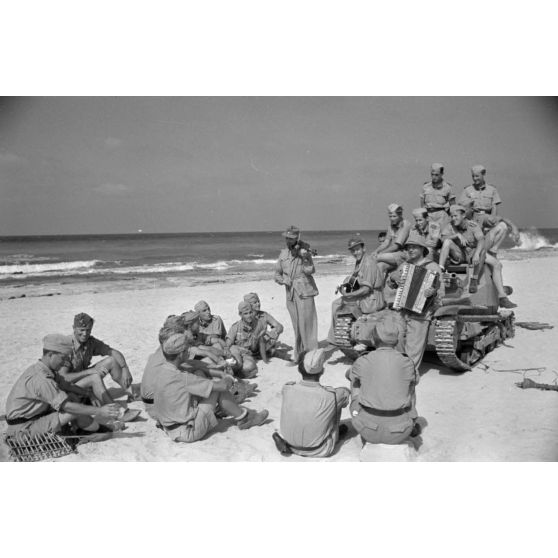 Sur une plage d'Egypte (El Quasaba), des membres de la KDF (Kraft durch Freude) jouent de la musique et chantent.