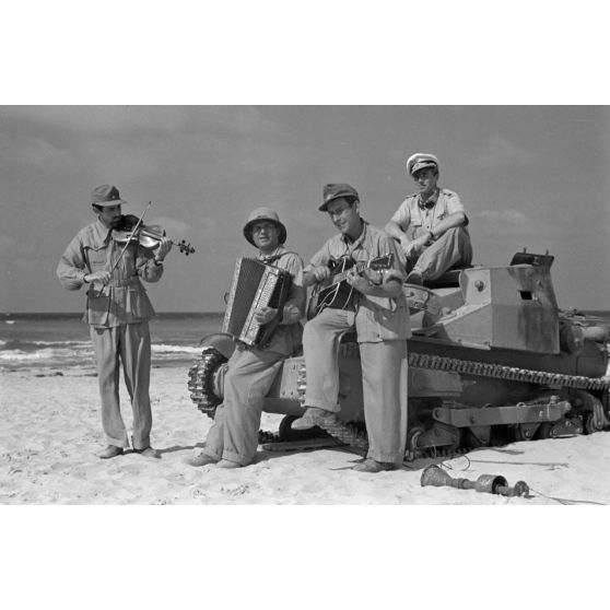 Sur une plage d'Egypte (El Quasaba), des membres de la KDF (Kraft durch Freude) jouent de la musique et chantent.